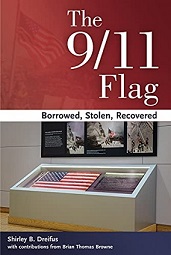 American flag displayed in glass and white museum case