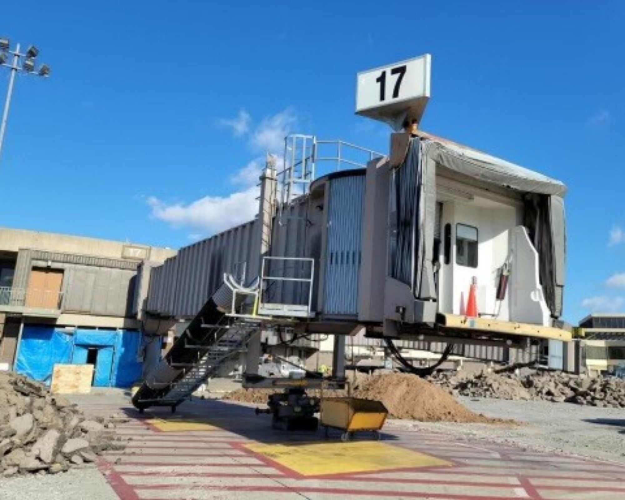 An airport gateway - with a sign that says "17" - sits amid rubble