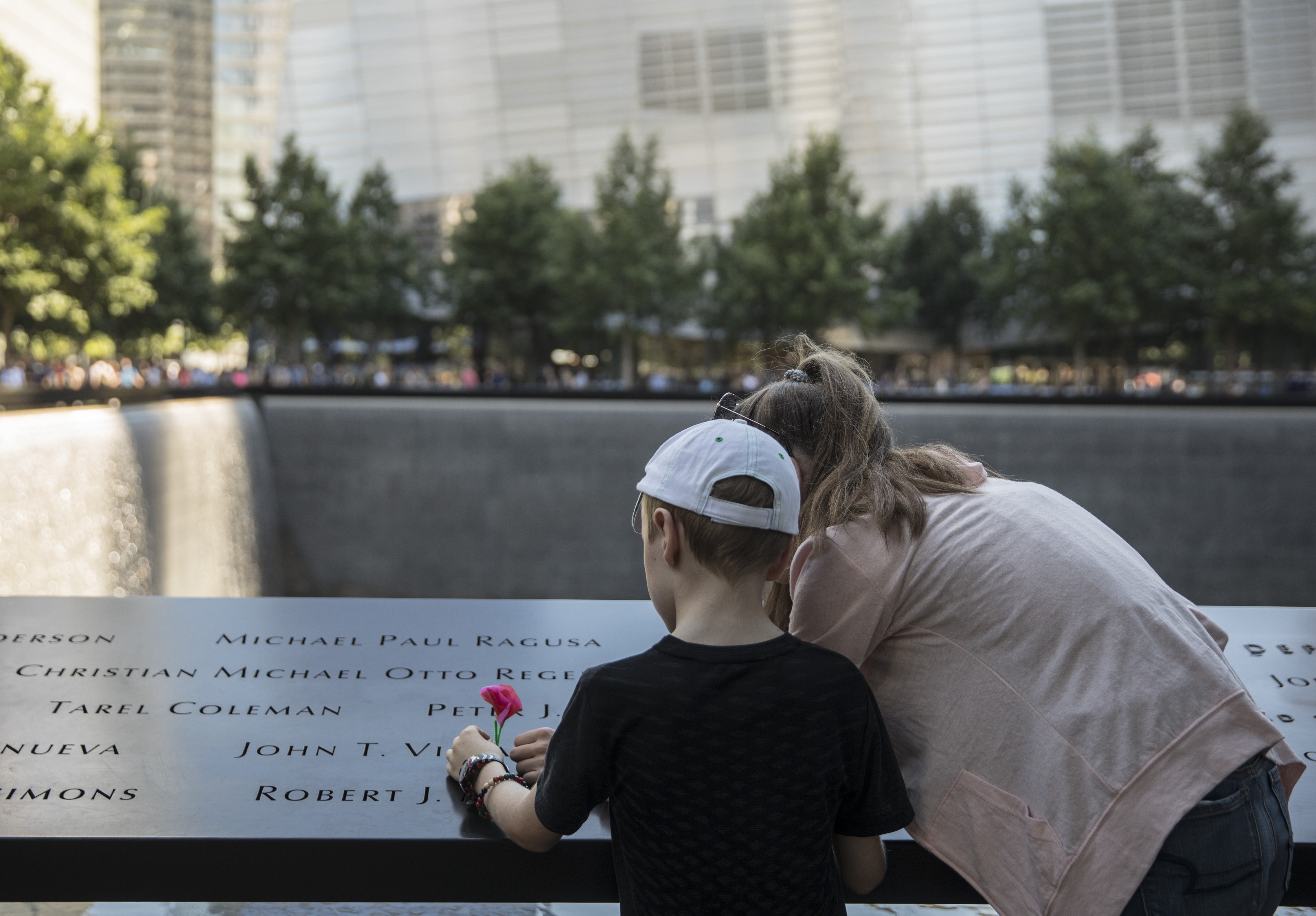 Back view of woman and child looking at the names on the Memorial 