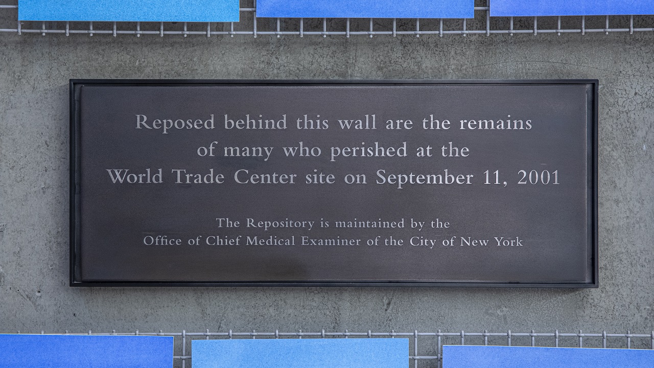 A plaque on the wall beside artist Spencer Finch’s installation “Trying To Remember the Color of the Sky on That September Morning” in Foundation Hall reads: “Reposed behind this wall are the remains of many who perished at the World Trade Center site on September 11, 2001. The Repository is maintained by the Office of Chief Medical Examiner of the City of New York.”