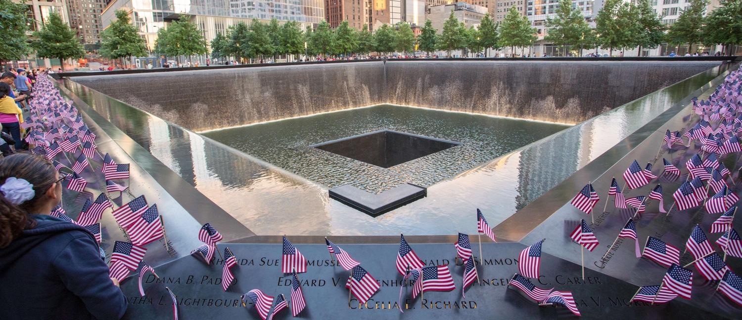  Small American flags line the bronze parapets that surround the Memorial pool where the South Tower once stood. The flags have been placed at the names of victims.