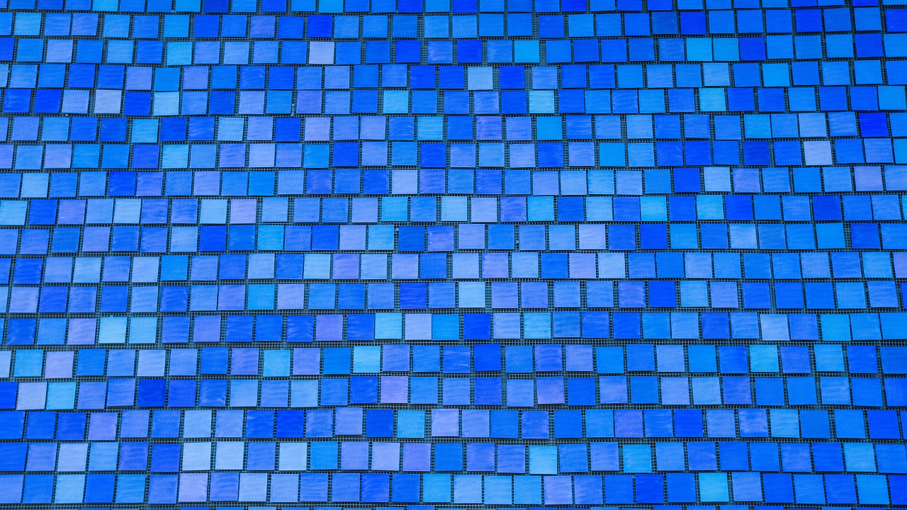 An array of dozens of blue tiles, none are the same shade of blue.