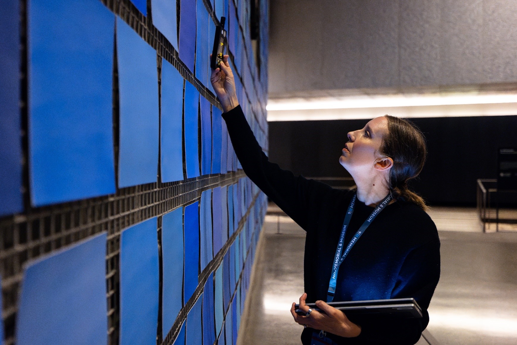 Woman works on the blue sections of the Spencer Finch art installation in the main hall of the Museum