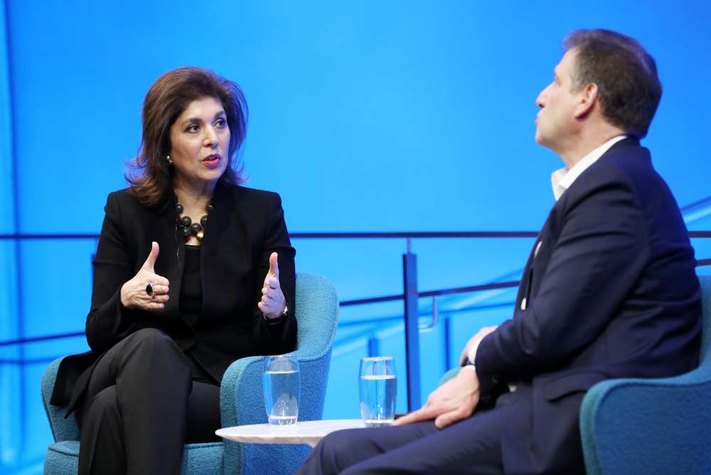 Author Farah Pandith gestures as she speaks with Foreign Affairs editor Gideon Rose onstage at the Museum auditorium. Rose is also speaking in the foreground and is slightly out of focus.