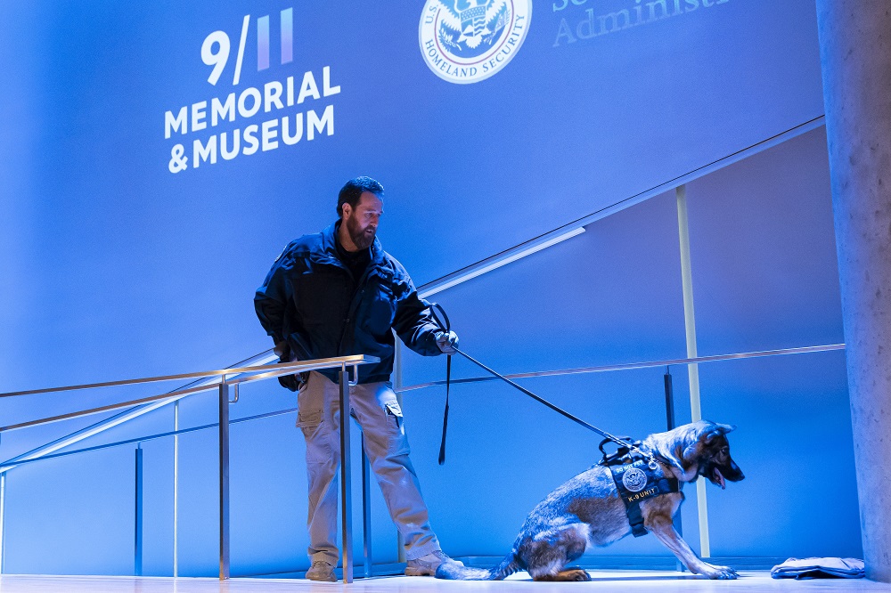 A dog handler performs a working dog demonstration in the 9/11 Museum auditorium.