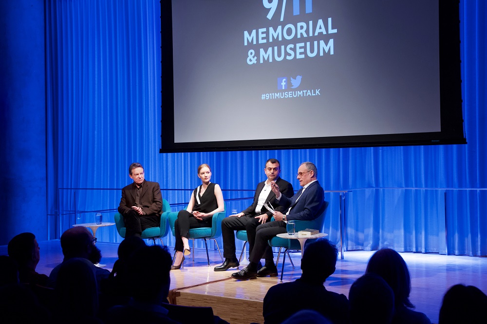 Three men and a woman take part in a moderated discussion on stage at the Museum.