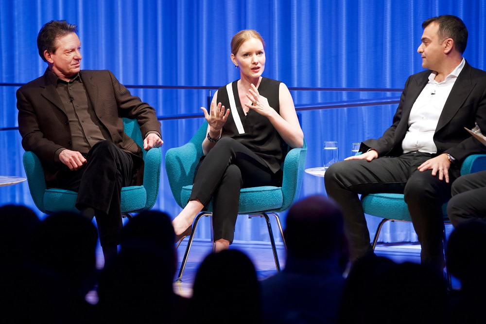 Three men and a woman take part in a moderated discussion on stage at the Museum.