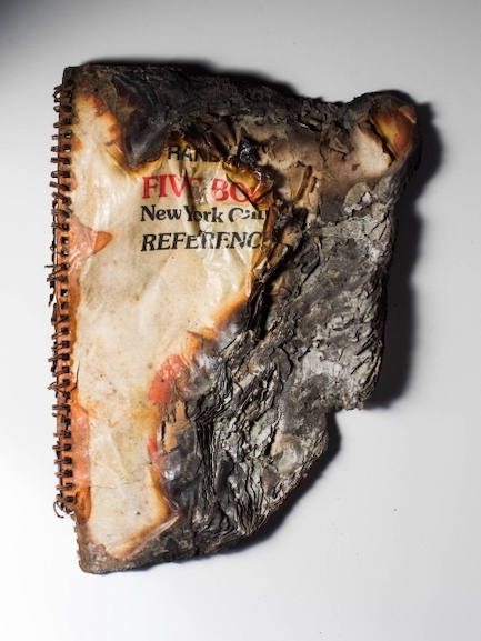 Charred remnants of a book of maps of New York's five boroughs