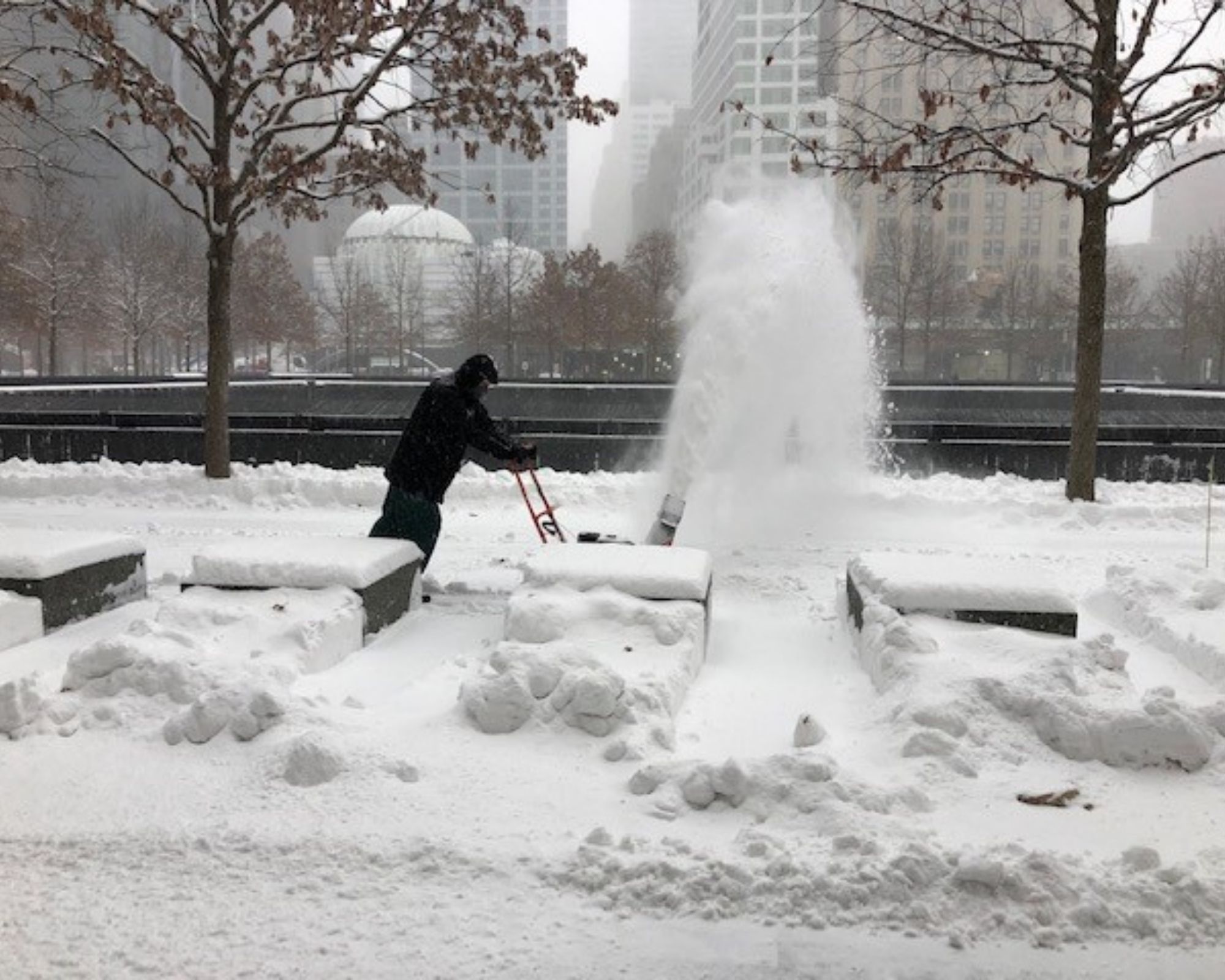 A worker blows snow off the Memorial 