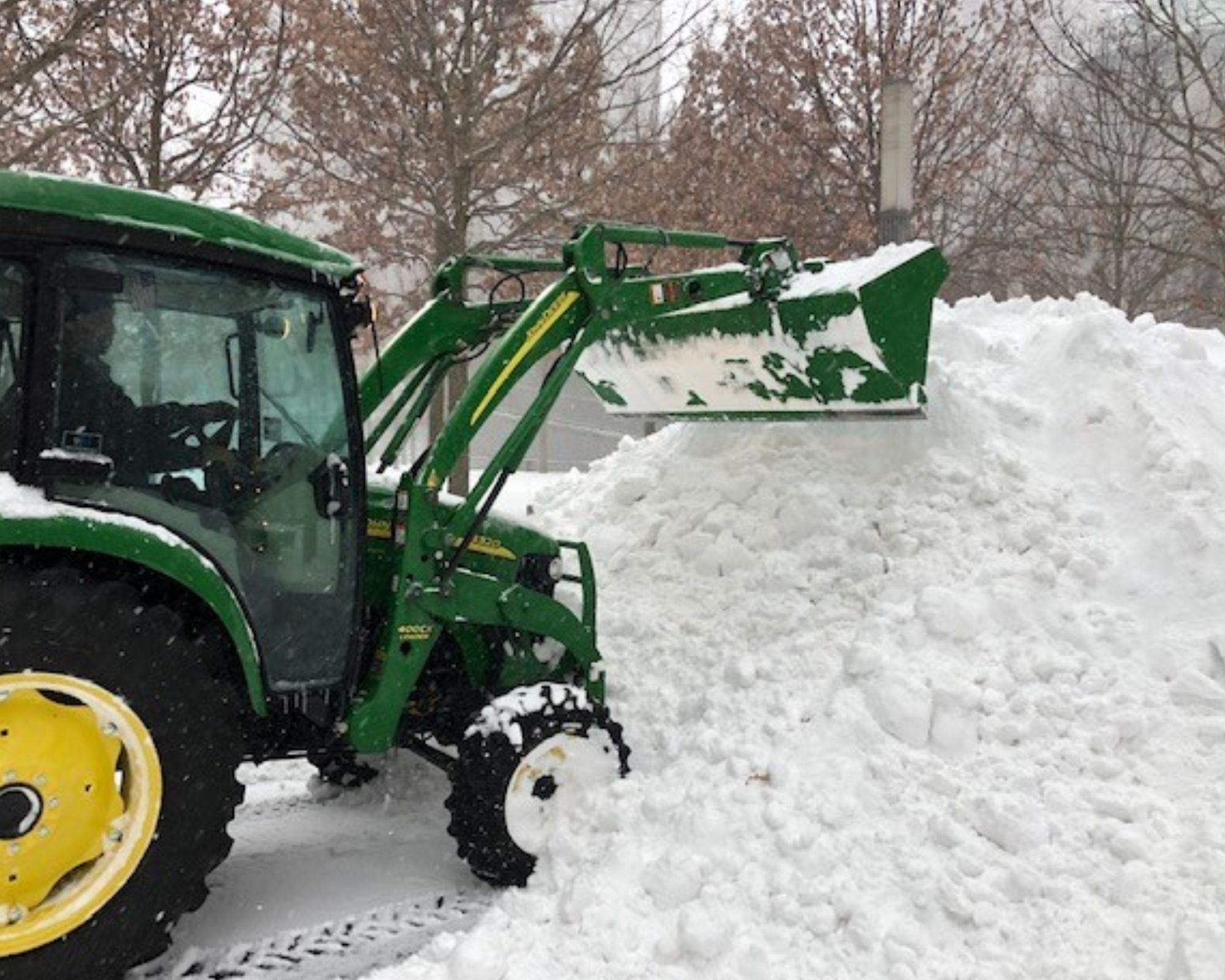 A dark green plough clears snow on the Memorial