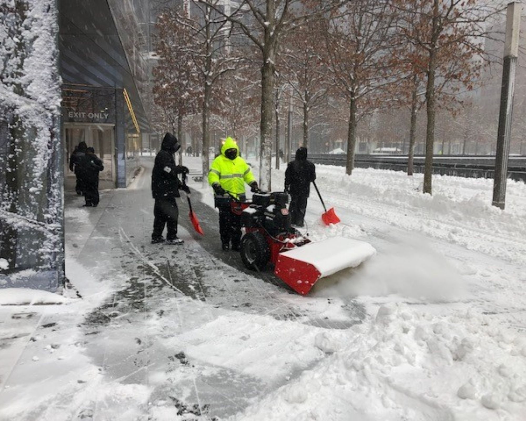Workers clear a path in the snow along the Memorial