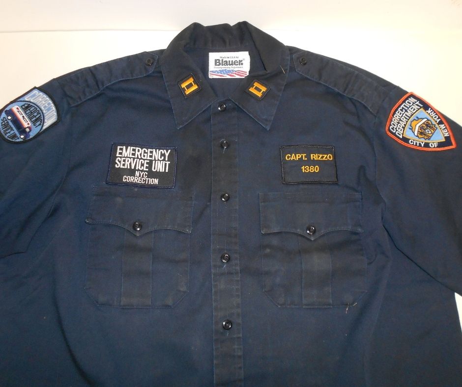 Navy blue shirt with badges, from the New York City Department of Corrections uniform