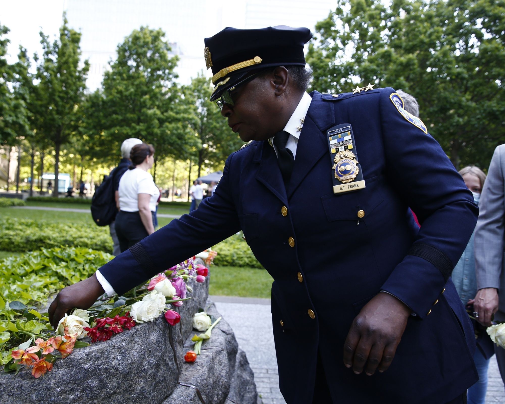 A uniformed officer lays a flower on the Memorial Glade