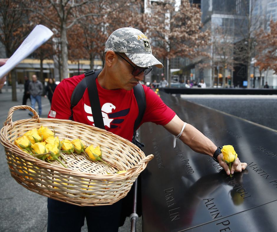 A volunteer places yellow roses on the Memorial to mark Veterans Day