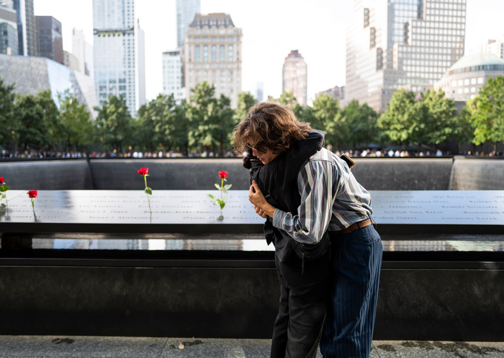 two people embrace in front of the Memorial