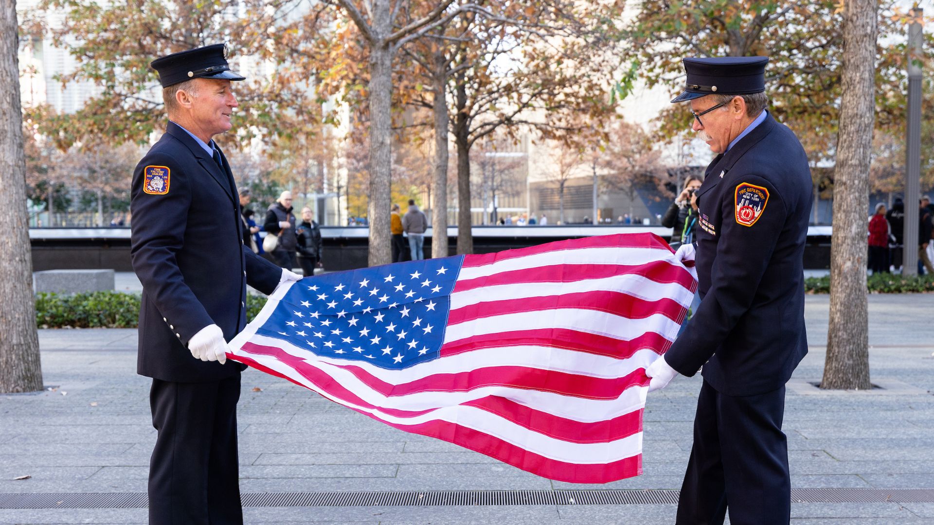 Uniformed officers folding an American flag on the Memorial plaza