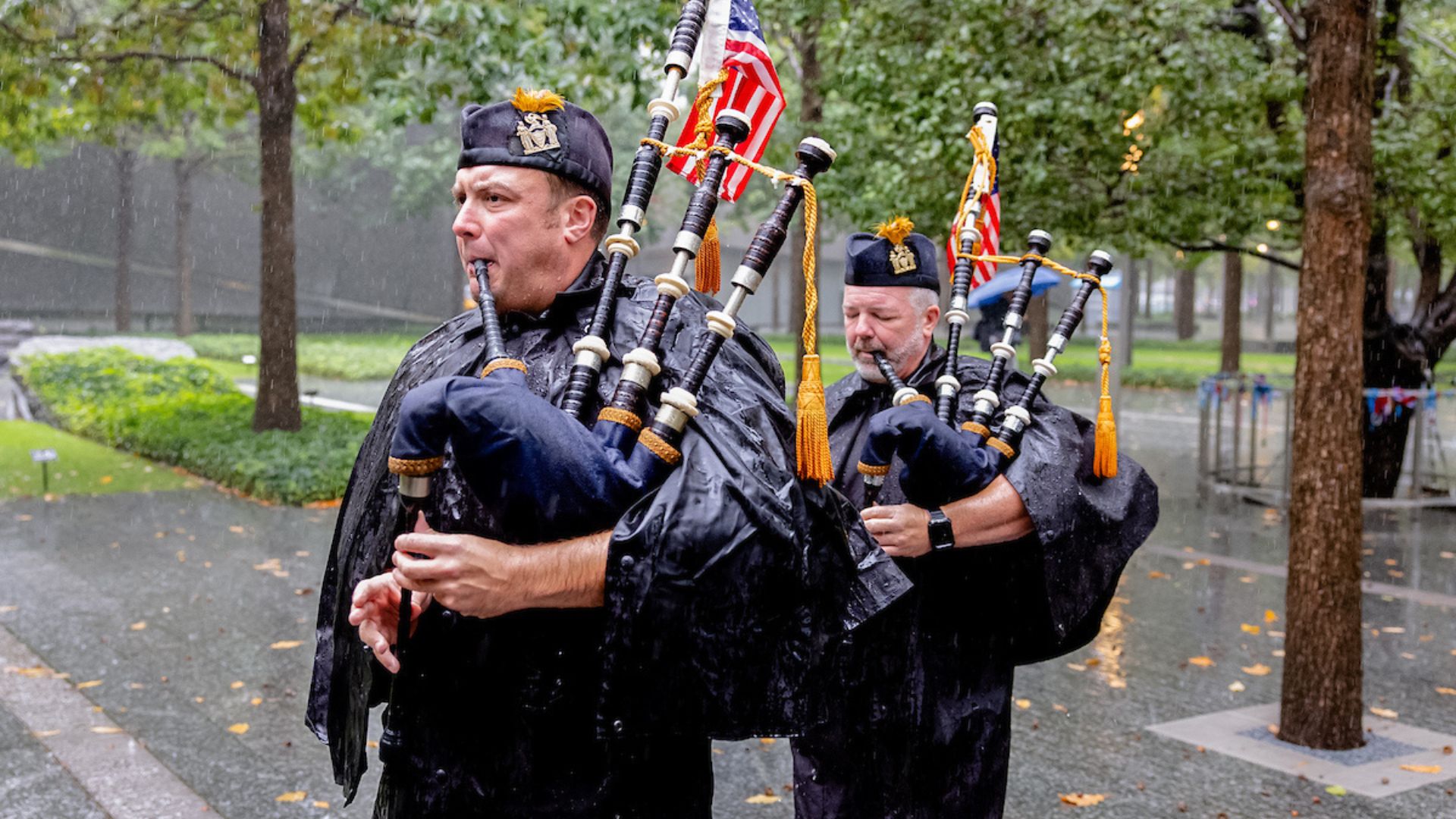 Two bagpipe players in the rain at the 9/11Memorial