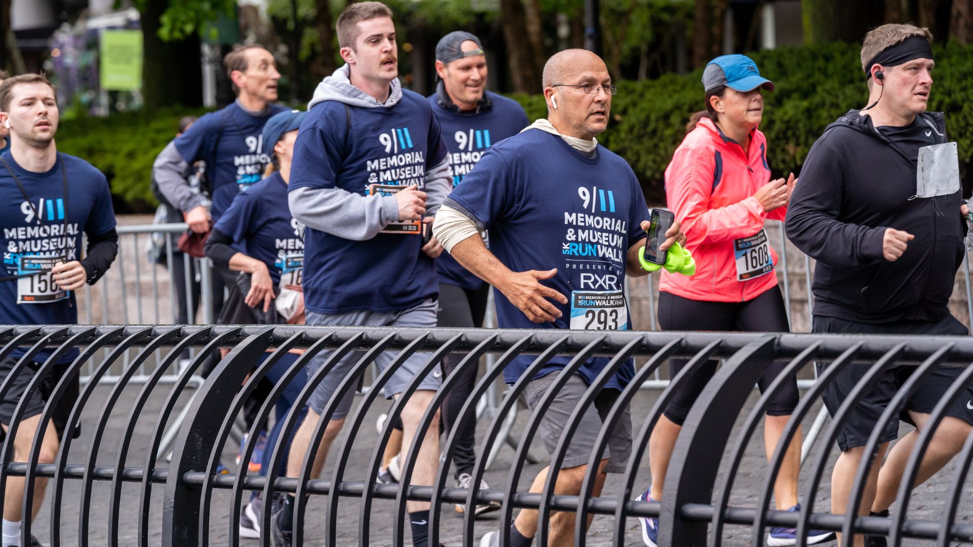 A group of runners behind a metal fence during the 5K