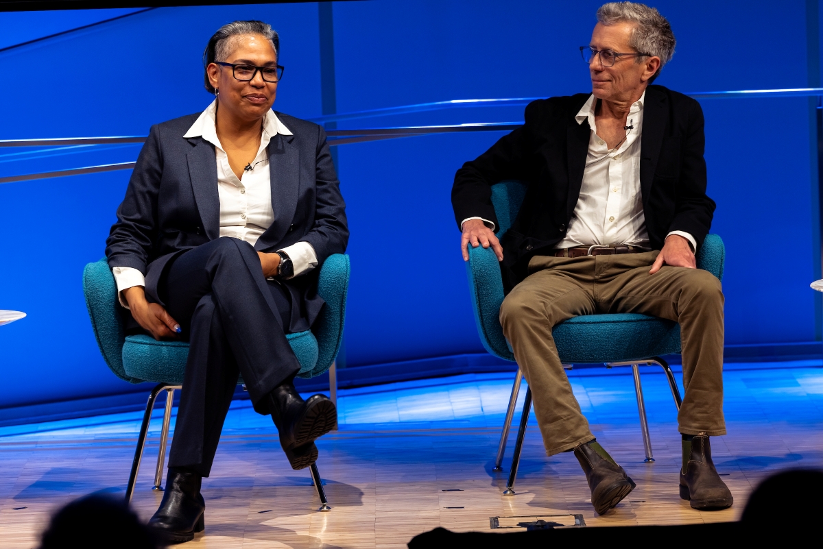 two speakers sit side by side on stage