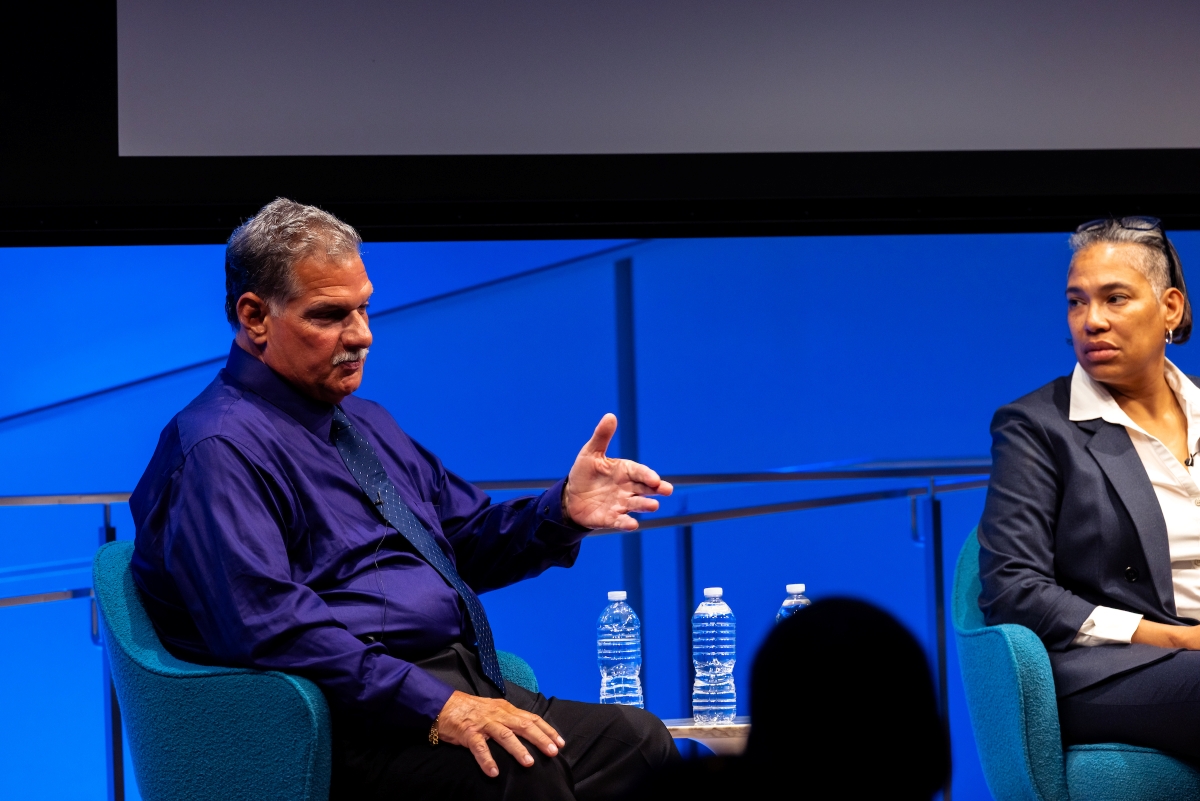 a panelists gestures while another panelist listens