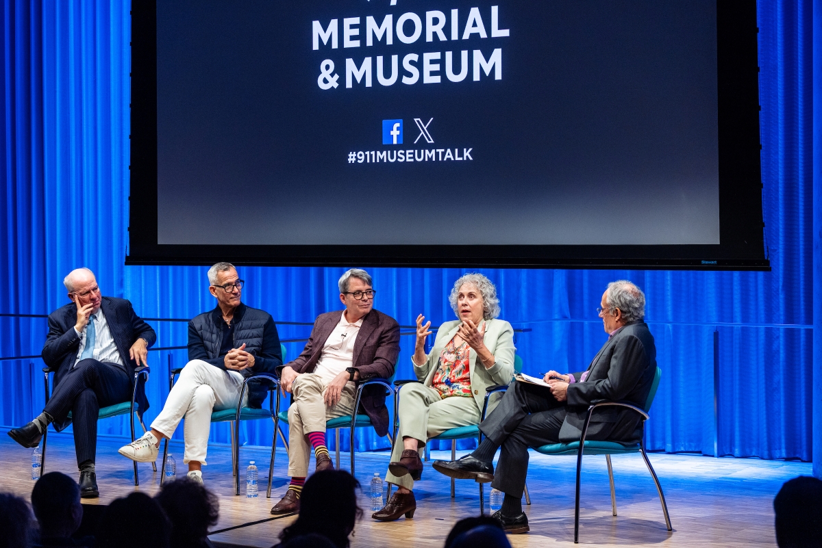 a group of five speakers sit on stage under a screen displaying the 9/11 Memorial & Museum logo
