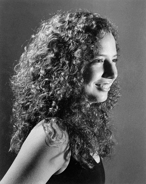 Maile Hale smiles in a professional, black-and-white portrait photo. 