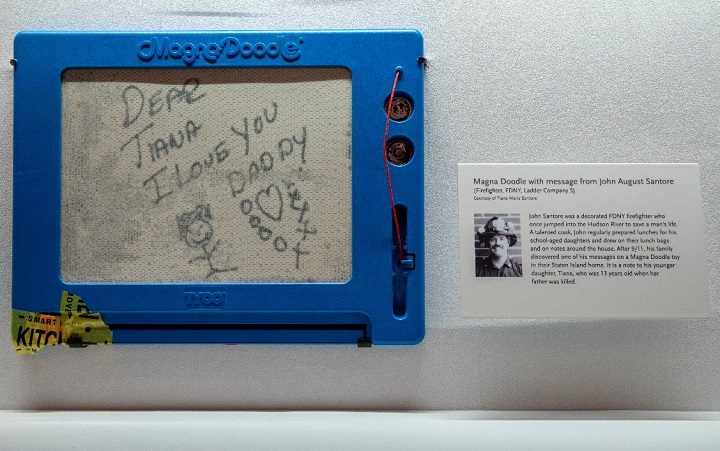 A photograph of the Magna Doodle affixed to an exhibition item display case in the "In Memoriam" gallery. 
