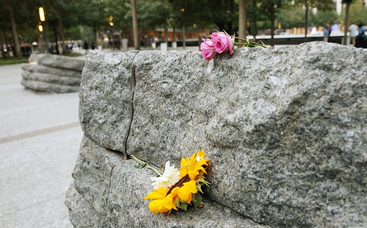 Pink and yellow flowers are left on one of the monoliths in the Memorial Glade. 