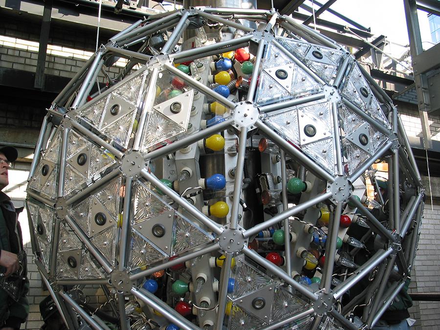 A large sphere made of unilluminated crystals and mult-colored light bulbs 