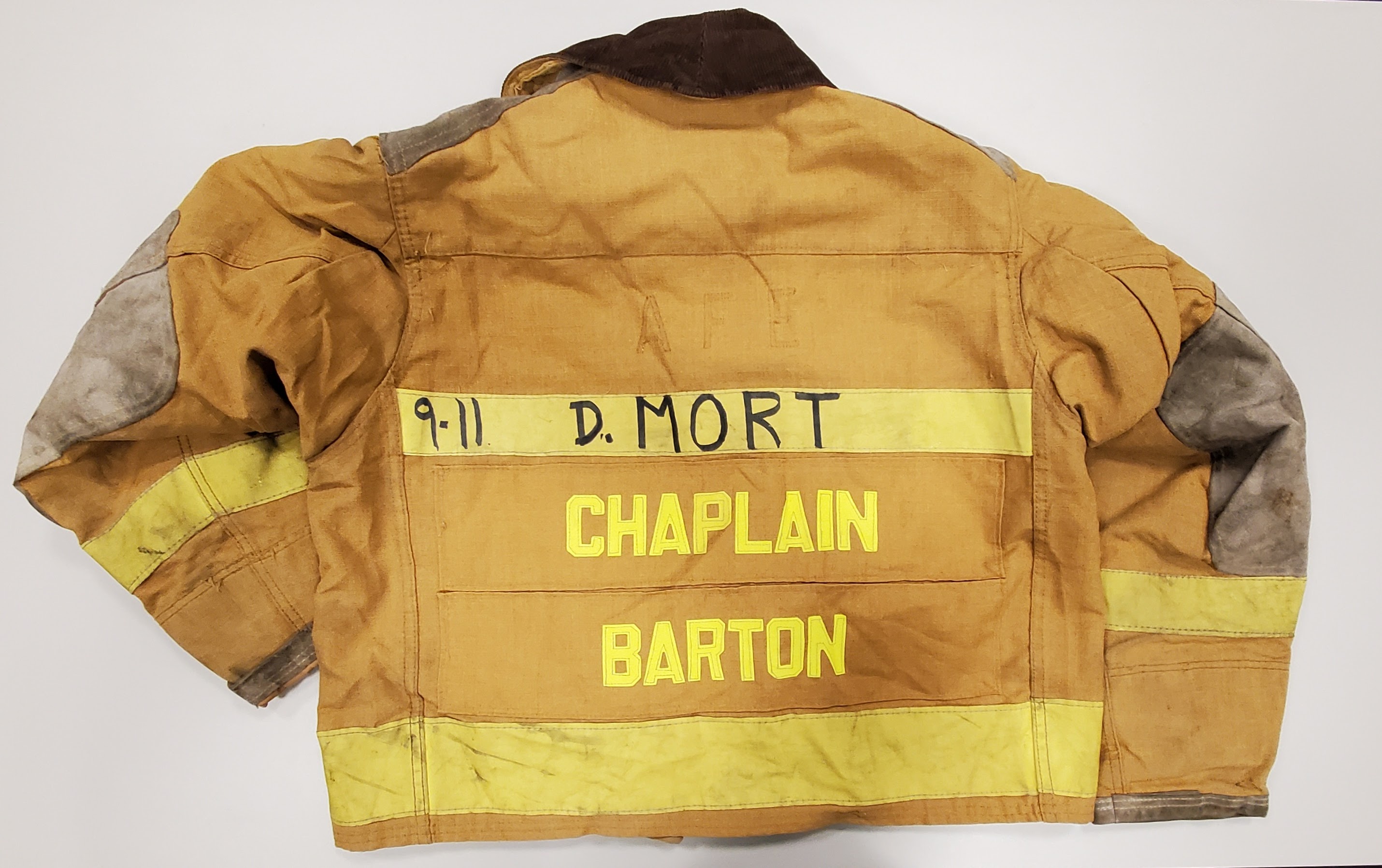 The back view of a gold and yellow jacket with the name CHAPLAIN BARTON embroidered in yellow 