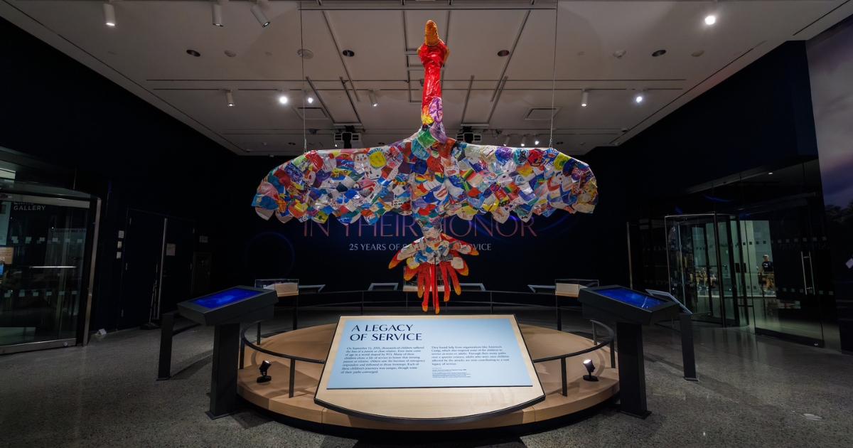 A phoenix sculpture made of multi-colored paper feathers, on which personal notes and artwork appear 