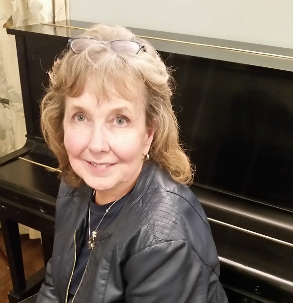 Kathy Dillaber, a survivor of the attack on the Pentagon, poses beside a piano.