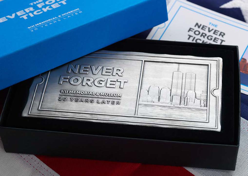 The metal Never Forget Fund commemorative ticket, displayed in a black box with a blue lid.