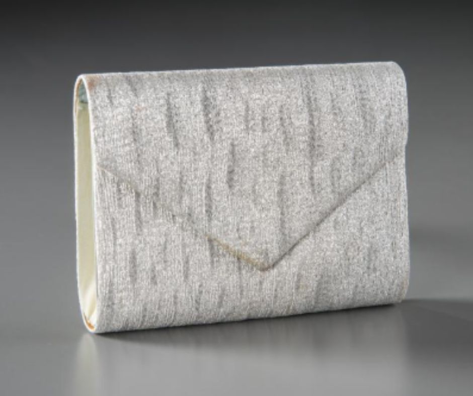 A shiny evening purse with an envelope closure, beaded in white and gray.