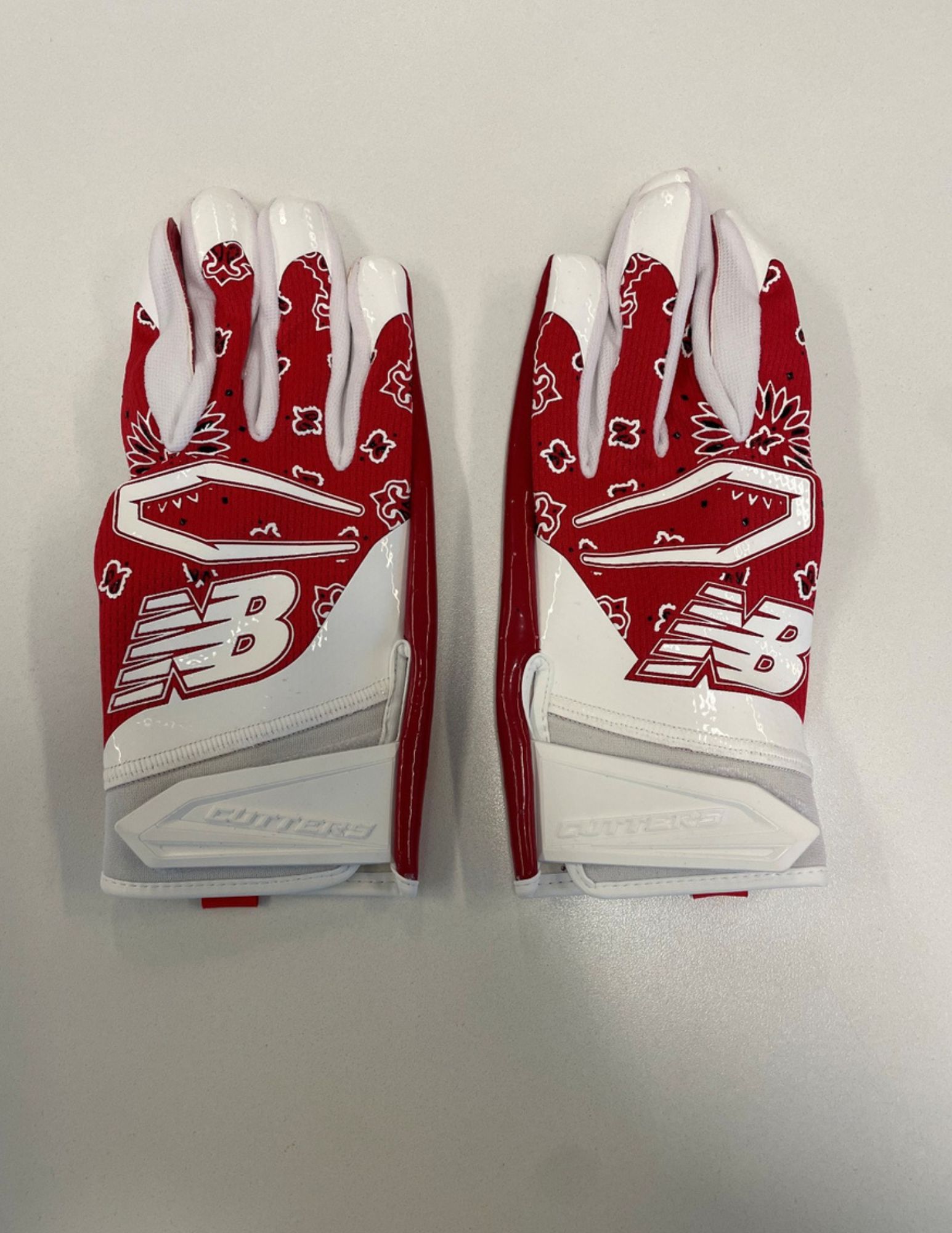 A  pair of red and white football gloves bearing a New Balance logo