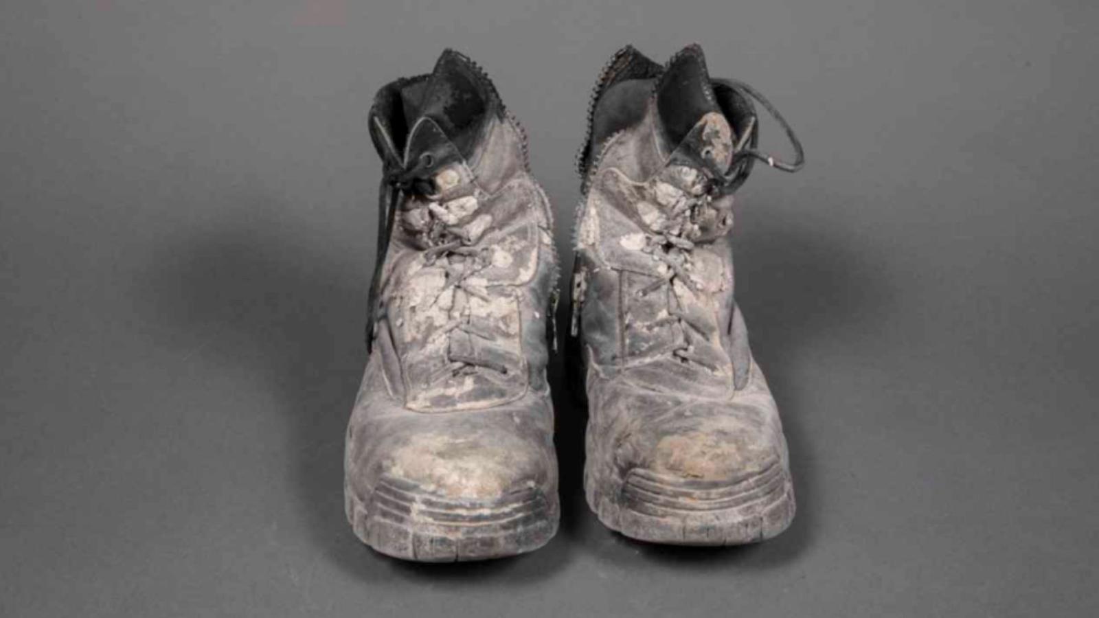 Battered work boots covered in dust and debris