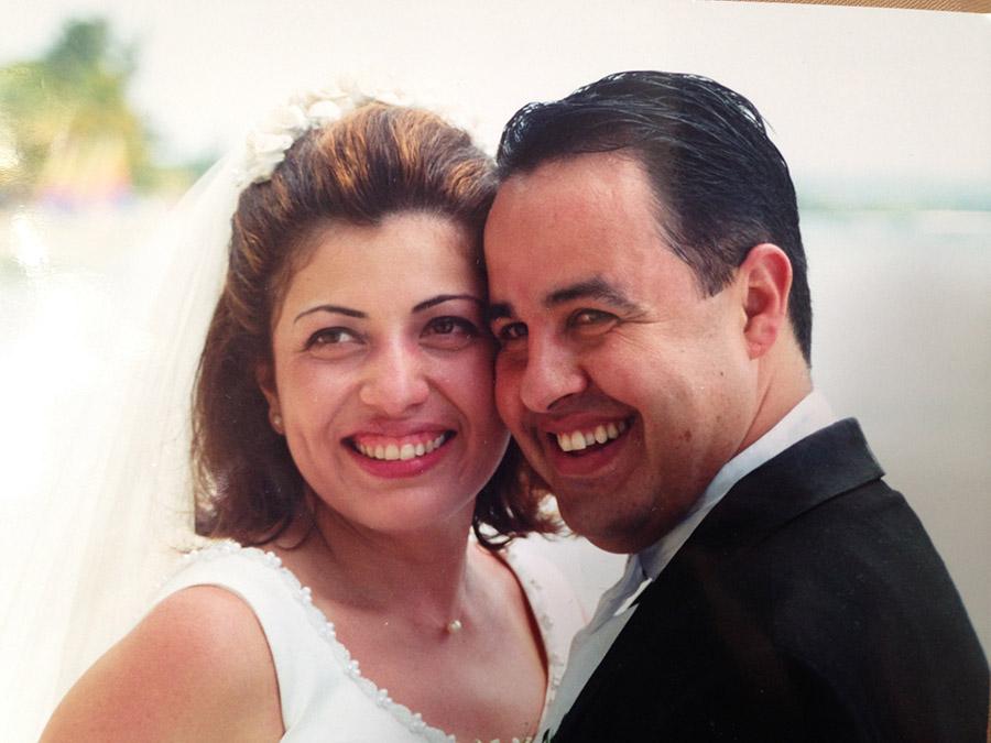 Carlos Lillo and his wife Haydee Cecilia Icaza-Lillo smile at their wedding in this close-up photo of their faces.