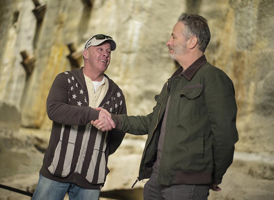 9/11 Memorial board member Jon Stewart and 9/11 responder and Feal-Good Foundation founder John Feal shake hands beside the slurry wall at the 9/11 Memorial Museum.