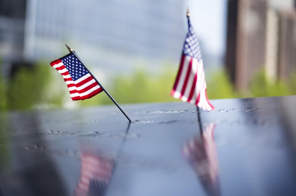 Two small American flags have been placed at adjacent names on the 9/11 Memorial.