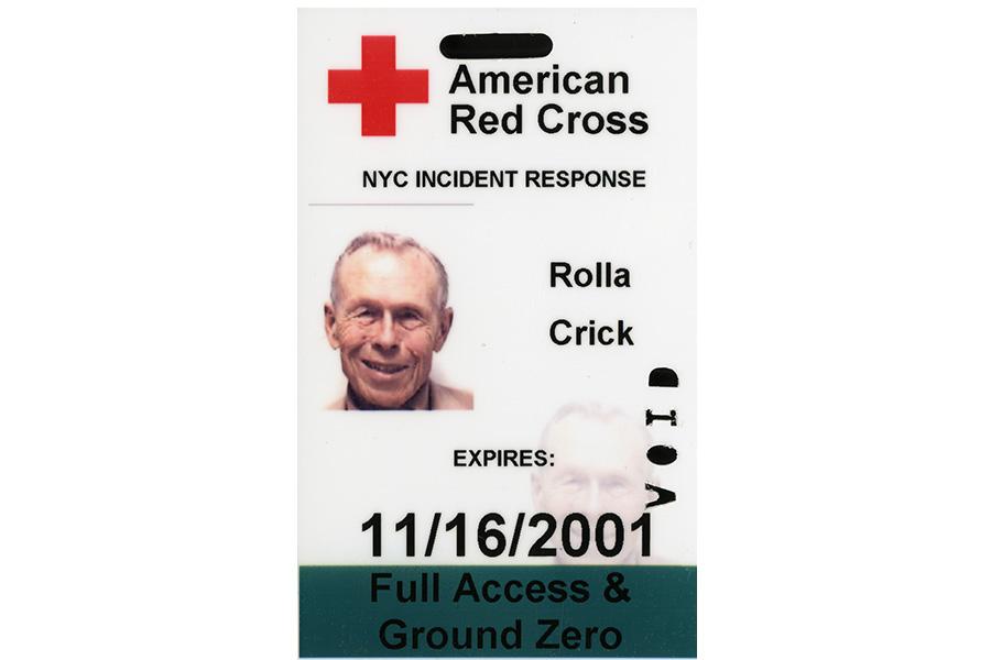 An access badge belonging to Rolla “Bud” Crick is displayed on a white surface. The badge features the logo of the American Red Cross across the top of it. The bottom of the badge reads, “Full Access and Ground Zero.”