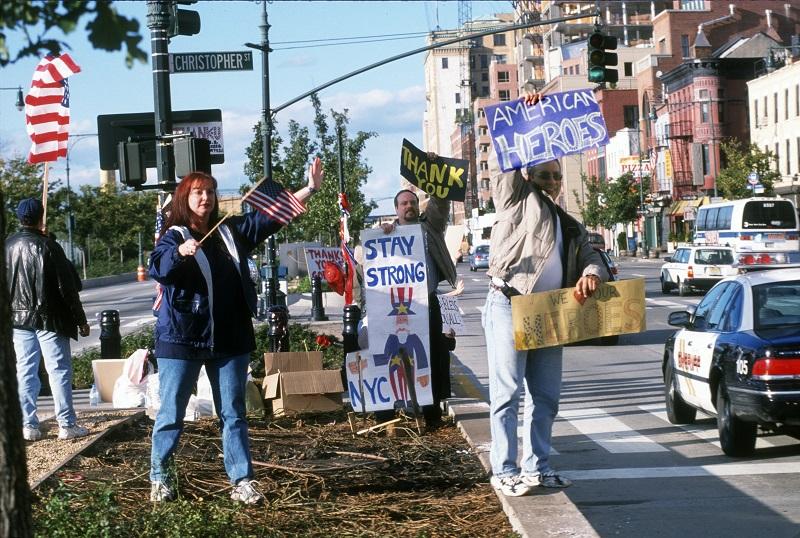 Several people stand in the median of the West Side Highway holding signs in support of rescue and recovery workers in the weeks after September 11. The signs they’re holding include messages like “Stay Strony NYC” and “We Love Our Heroes.”