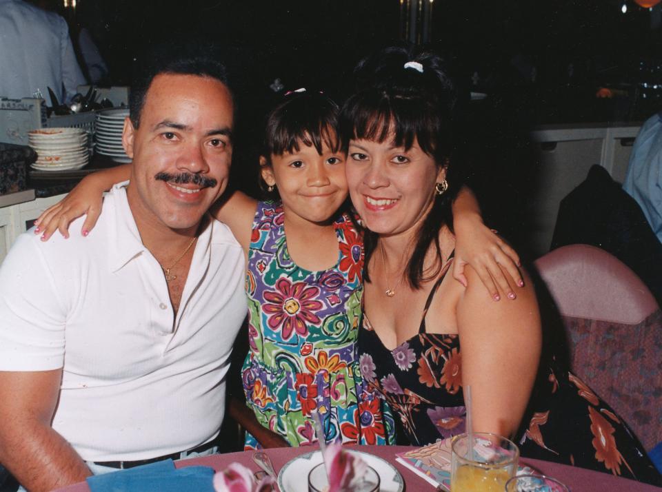 Ramon Suarez, Carmen Suarez, and their young daughter Jillian Suarez smile as they pose for a photo.