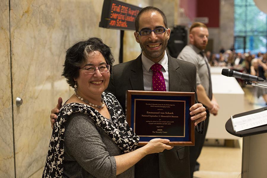 Emmanuel Von Schack and Betty Siegel smile as they hold up an award at the Kennedy Center.
