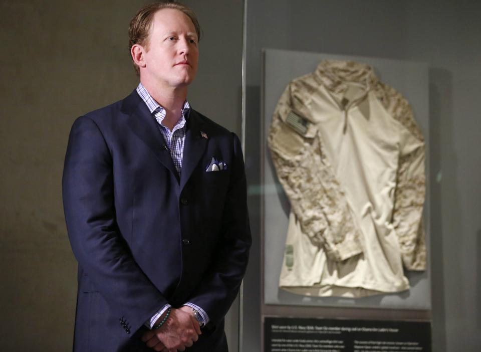 Former U.S. Navy SEAL Team 6 member Robert O’Neill stands in front of the shirt he wore during Osama bin Laden’s death, which is on display at the 9/11 Memorial Museum.