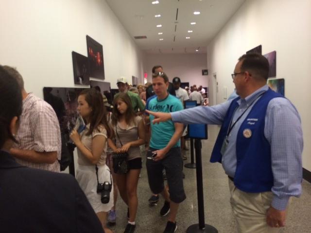 Volunteer Angel Caballero helps visitors outside of the Museum’s showing of “Rebirth at Ground Zero.”