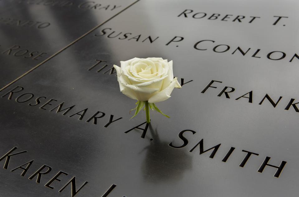 A white rose stands at the name of Rosemary Smith on the 9/11 Memorial.