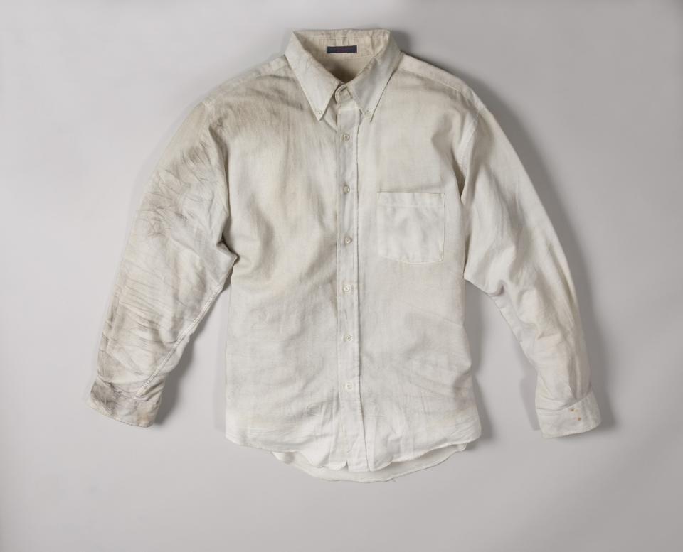A smoke-stained white dress shirt worn by Walter Travers on February 26, 1993 is displayed on a white surface at the Museum.