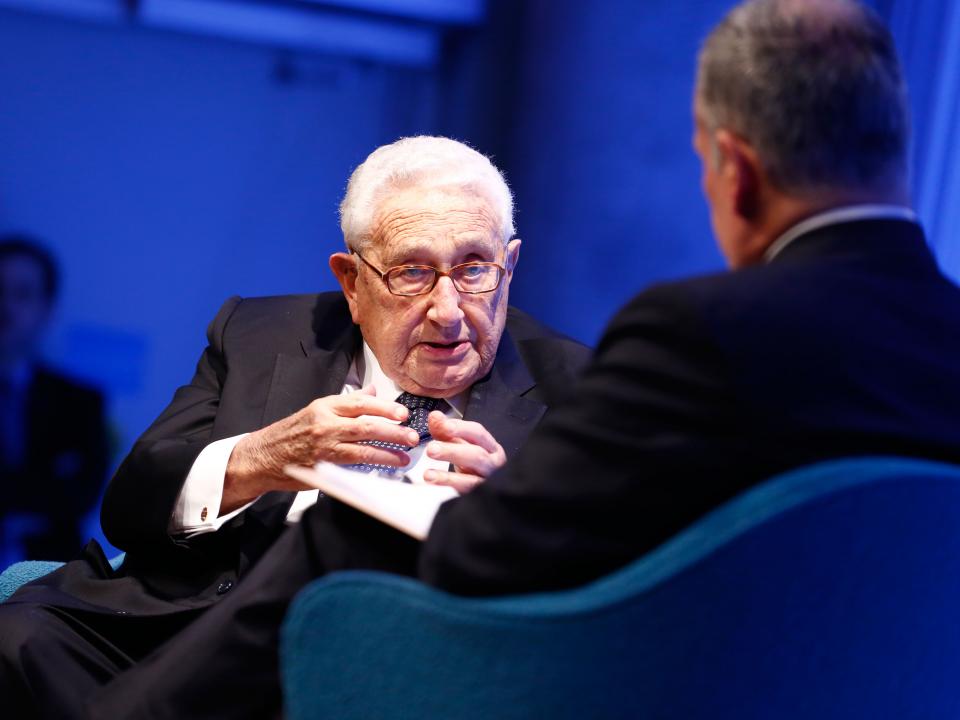 Former U.S. Secretary of State Henry Kissinger gestures as he speaks with Clifford Chanin, the executive vice president and deputy director for museum programs.