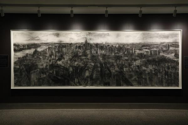 Artist Torild Stray’s black and whtie, charcoal drawing New York Metamorphosis shows an aerial view of Manhattan looking north from downtown.