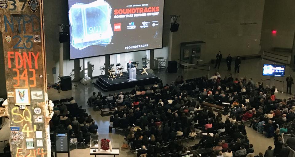 More than 500 people are seated as they attend a special Tribeca Film Festival screening of CNN’s “Soundtracks: Songs That Defined History.” A man is onstage in front of a large screen in Foundation Hall, and the Last Column can be seen in the foreground.